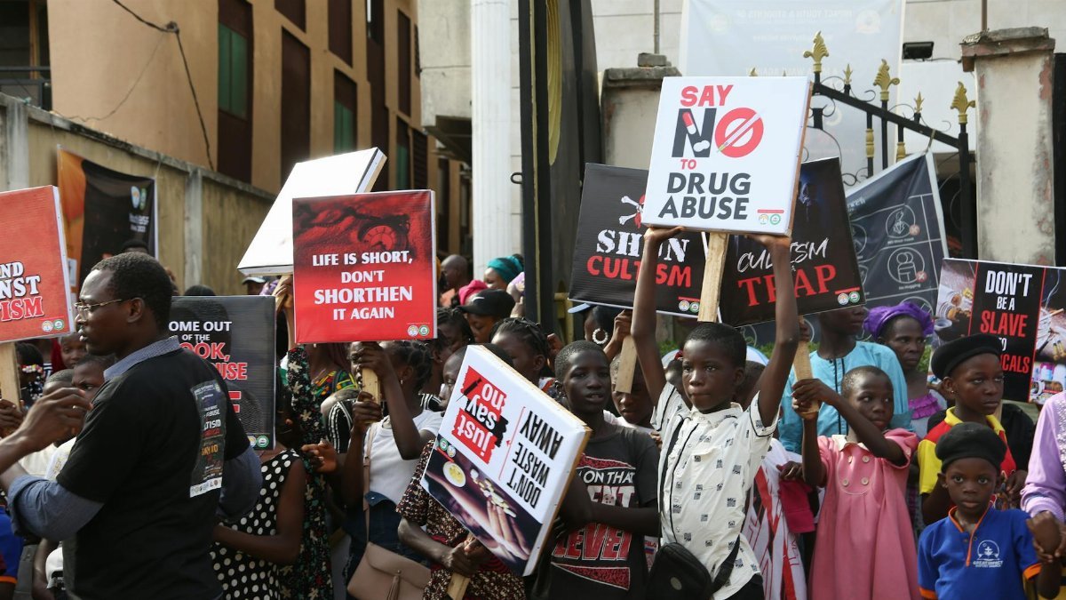 Group of people protesting against drug abuse, holding placards with slogans.