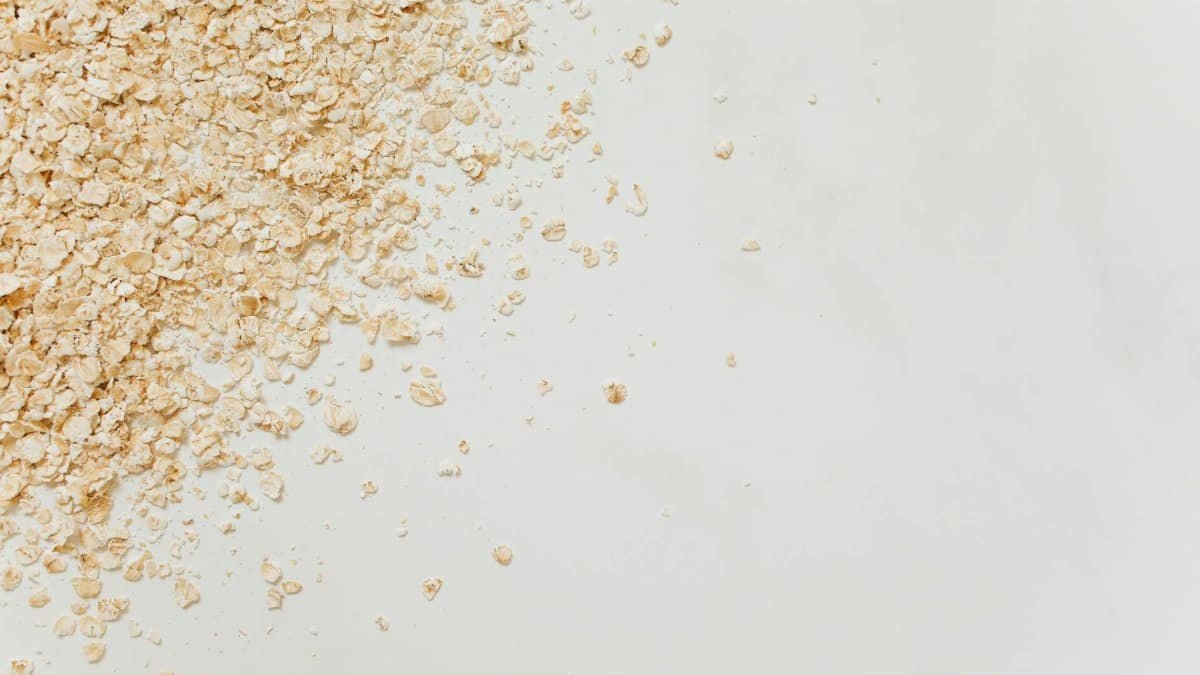 Close-up of scattered oatmeal on a clean white background, perfect for food-related themes.