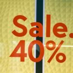 Bright retail sale sign showing 40 percent discount on yellow background.