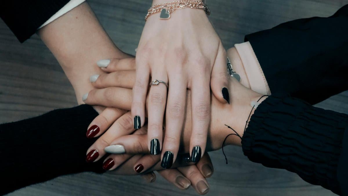 Close-up of diverse hands stacking together symbolizing teamwork, unity, and collaboration.