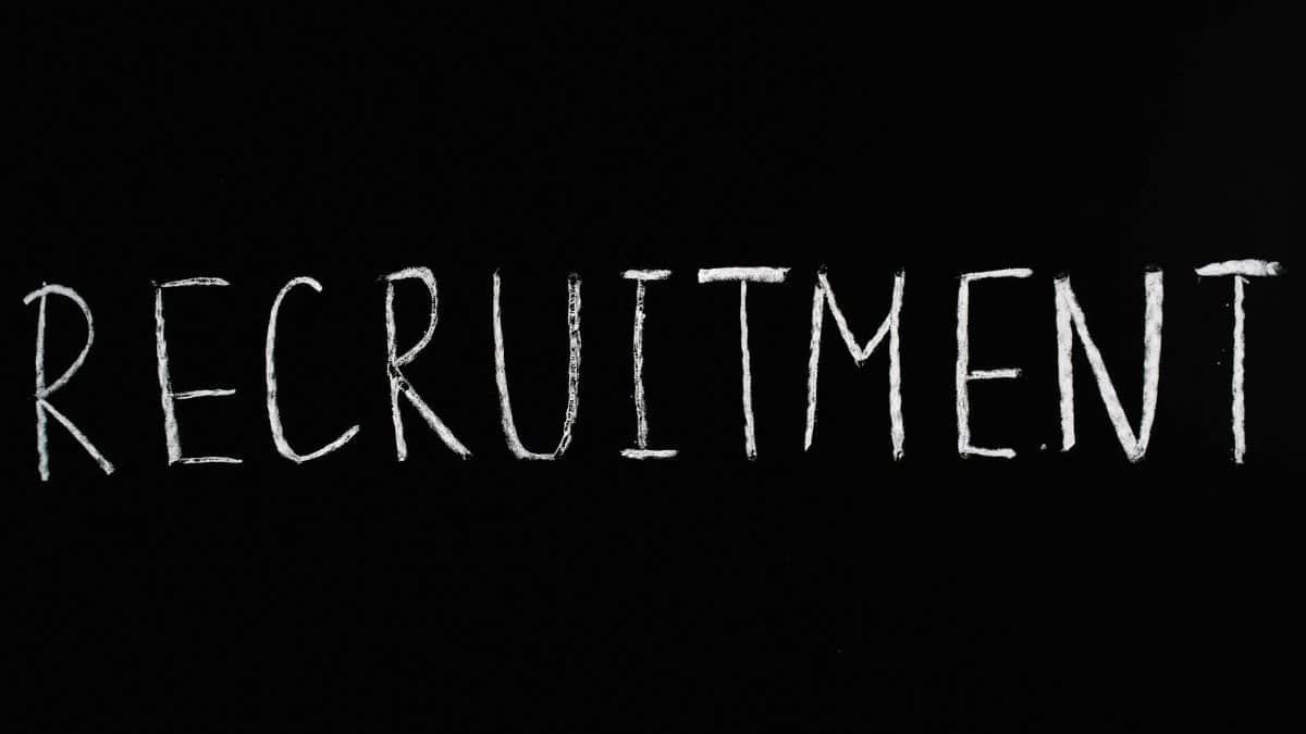 Chalk-written 'RECRUITMENT' on a black chalkboard, ideal for HR and hiring themes.