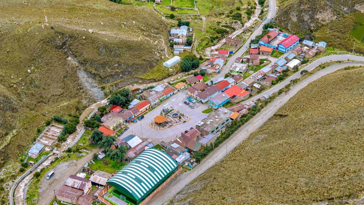 Aerial view capturing a vibrant village nestled in Peru's mountainous landscape.