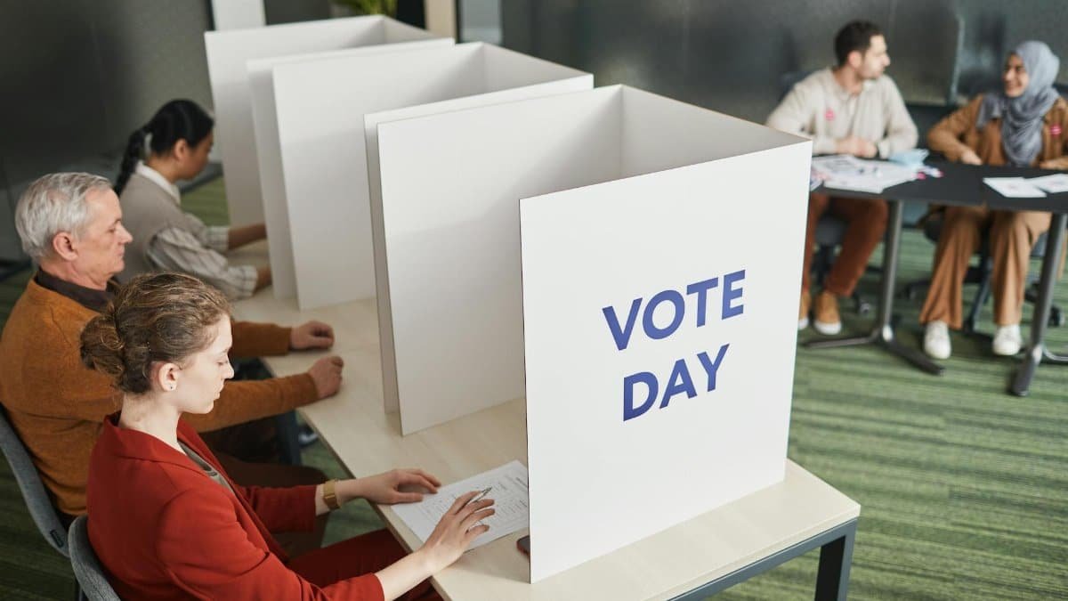 People casting votes in a polling station on election day, emphasizing civic engagement.