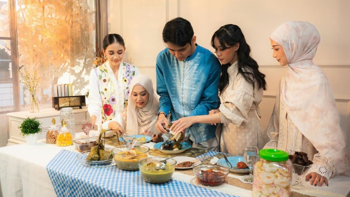 A group of adults enjoying a festive meal indoors, dressed in traditional attire, creating a warm and inviting atmosphere.