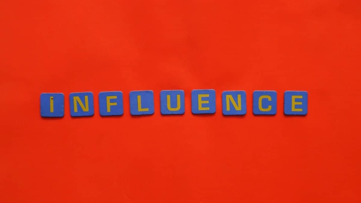 Bold blue letters spelling 'Influence' on a vibrant red background, conveying impact.
