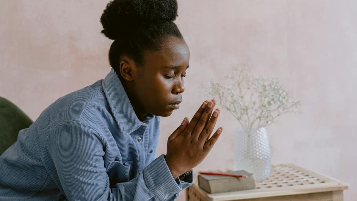 Serene image of a woman with eyes closed in prayer, symbolizing faith and devotion.