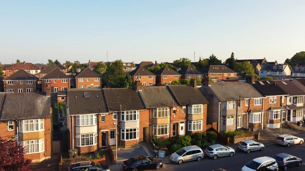 Aerial view of a peaceful residential neighborhood with traditional brick houses in Luton, UK during a sunny day.