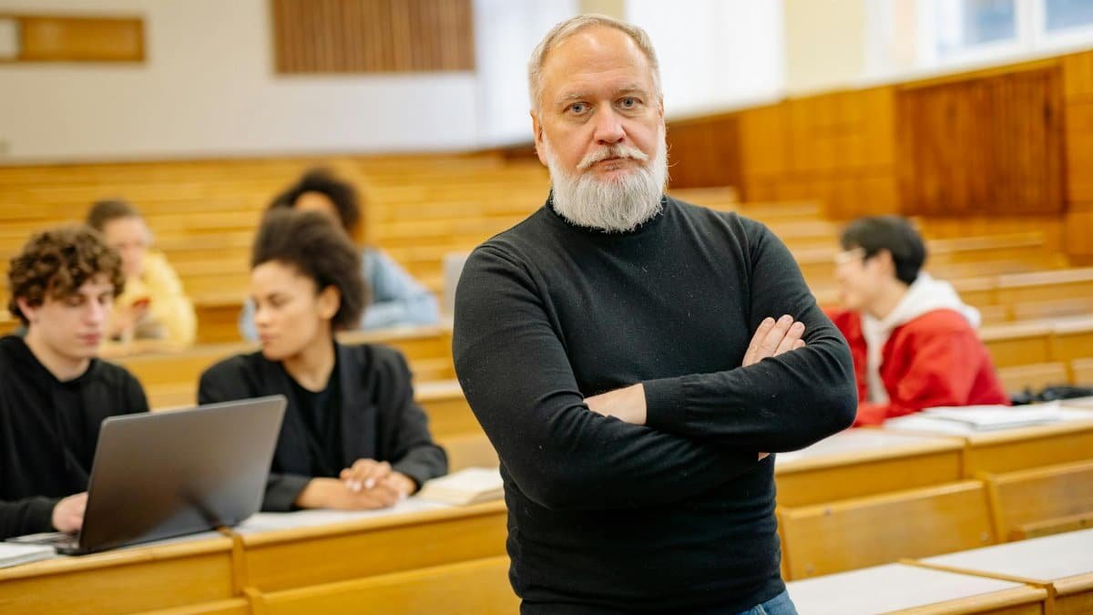 Confident professor in lecture hall with diverse students engaged in learning.