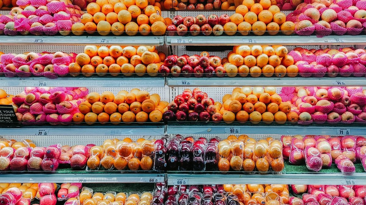 Colorful variety of fresh fruits neatly arranged on supermarket shelves, showcasing abundance and freshness.