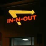 Bright neon In-N-Out sign glowing at night outside a restaurant in California.