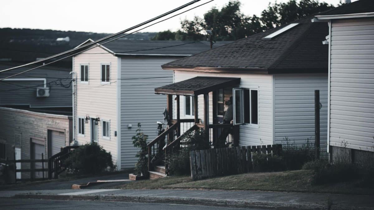 Peaceful residential street with houses and power lines during dusk, creating a quiet suburban atmosphere.