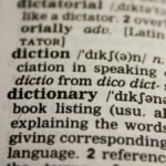 Detailed close-up view of a dictionary page highlighting the word 'dictionary' and its definition.