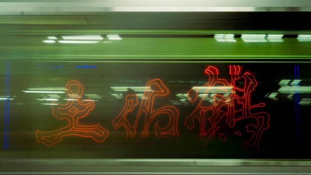A moving train with neon lights in Chiyoda City, Tokyo, showcasing modern urban night aesthetics.