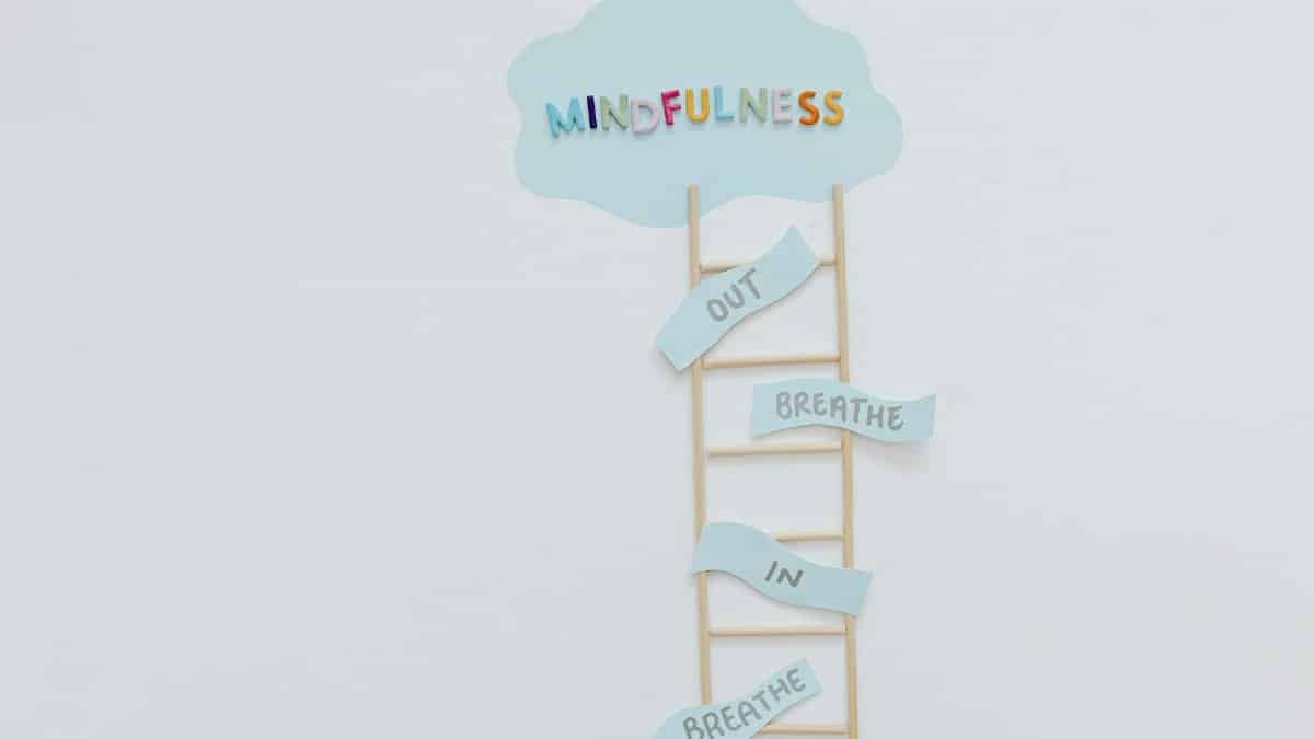 Creative mindfulness concept with ladder, words, and cloud shape for mental well-being.