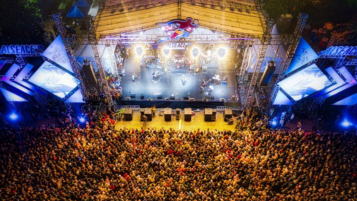 A lively aerial shot showcasing a large concert crowd at a bustling music festival.