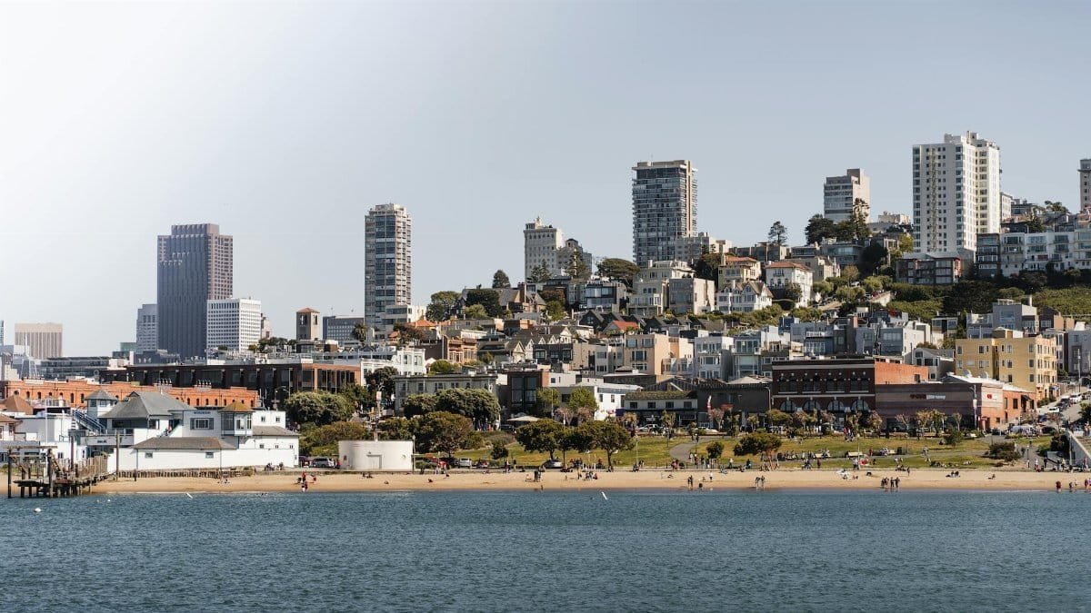 A scenic view of San Francisco's coastal skyline with beachfront and urban landscape.
