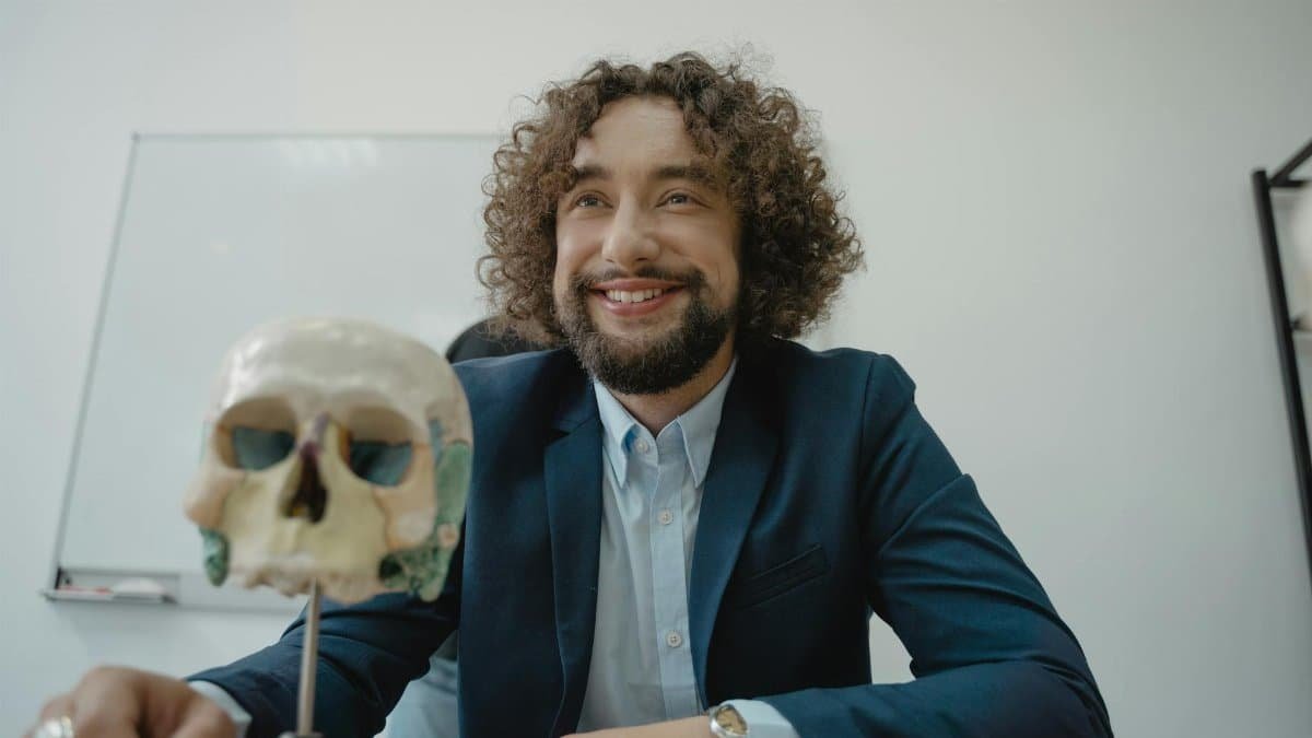 Engaging teacher with a model skull in a classroom, symbolizing knowledge and science education.