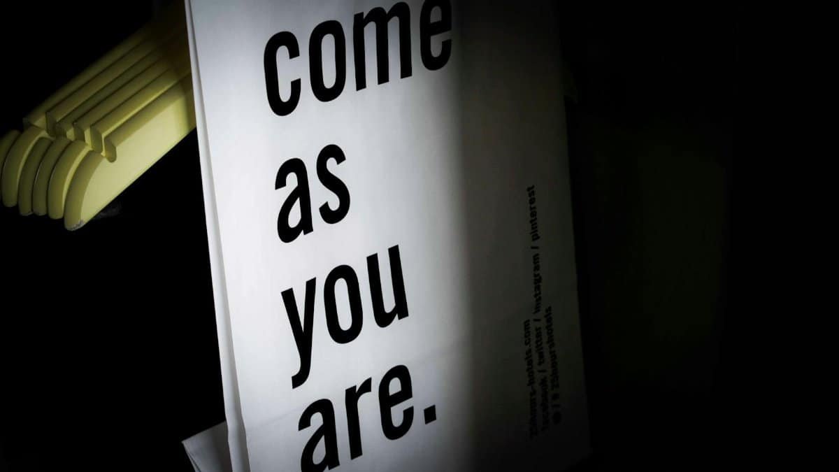 Set of similar hangers and shopping paper bag with inscription hanging in wardrobe