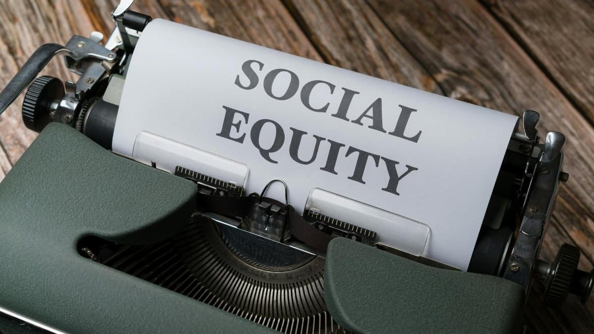 Close-up of a vintage typewriter displaying the message 'Social Equity' on paper.