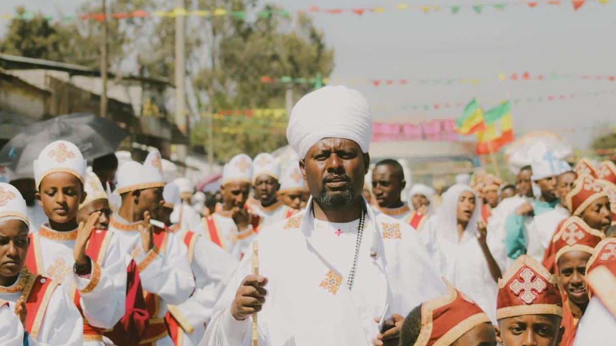 A vibrant parade of Ethiopian Orthodox Christians in traditional clothing during a religious festival in Addis Ababa.