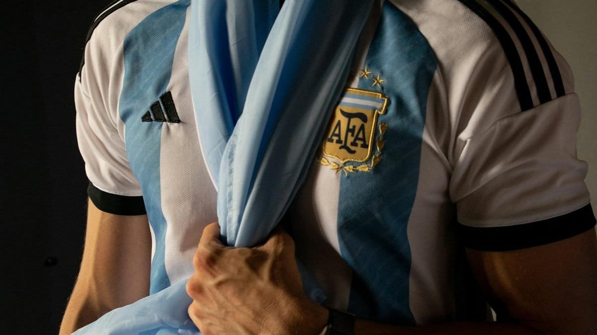 Close-up of a man holding an Argentina soccer jersey symbolizing sports enthusiasm.
