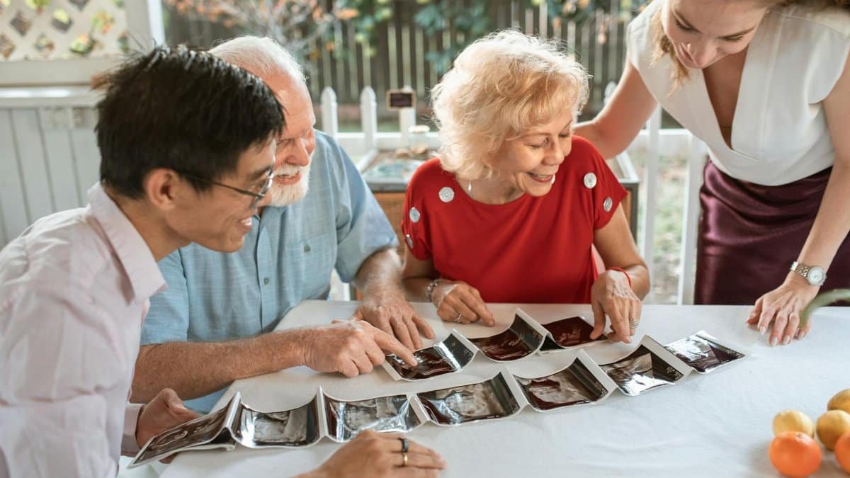 A happy family celebrating a pregnancy announcement with ultrasound photos.