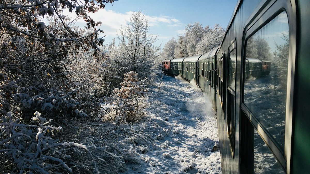 A scenic train ride through a snow-covered landscape in Velingrad, Bulgaria, captures winter's beauty.