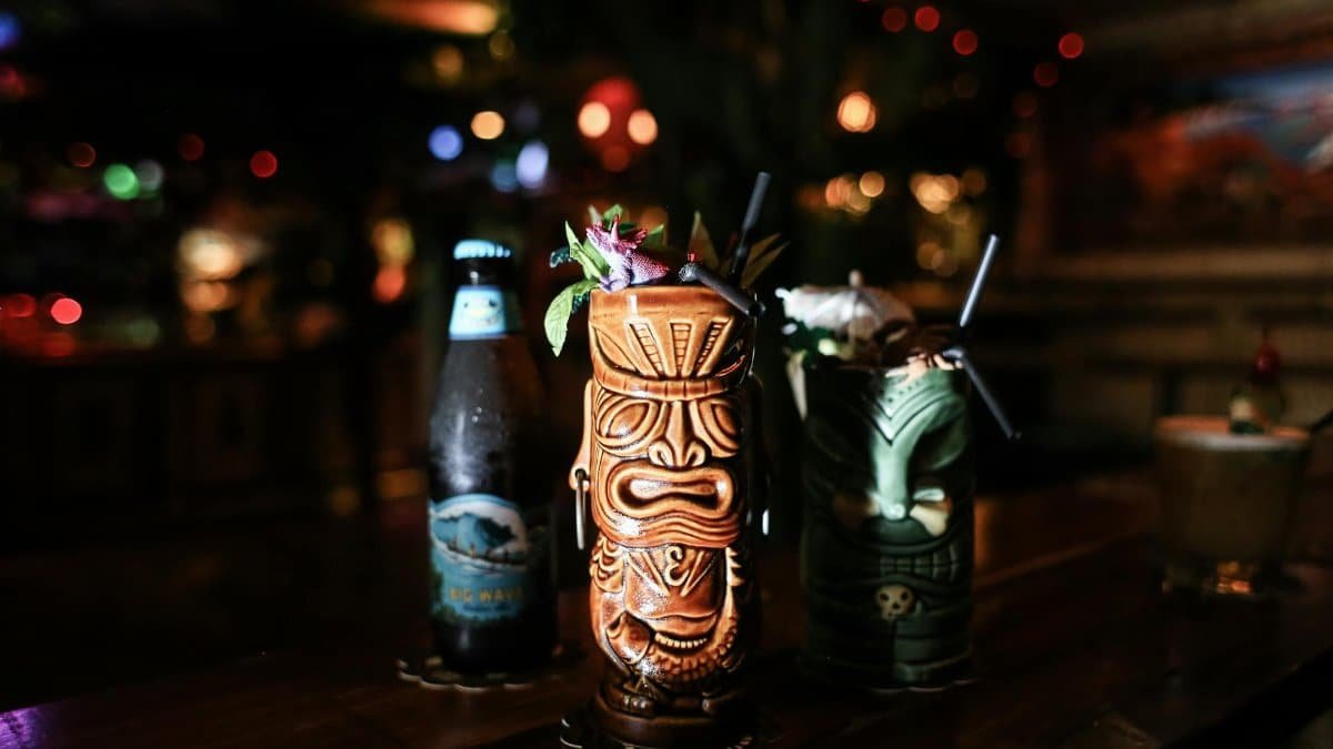 Vibrant tiki cocktails with bokeh lights in a cozy bar. Perfect for festive gatherings and exotic drinks.