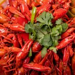 A vibrant plate of spicy crawfish garnished with fresh cilantro, ready to savor.