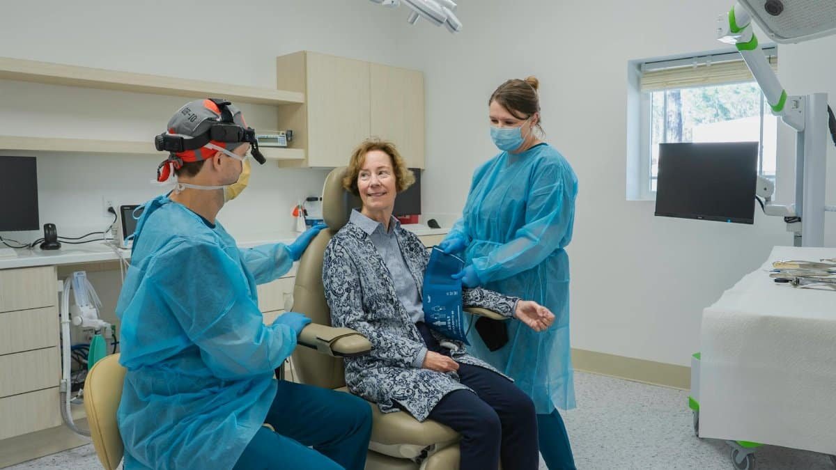 Patient receiving dental checkup in modern clinic with two professionals in Brunswick, Georgia.