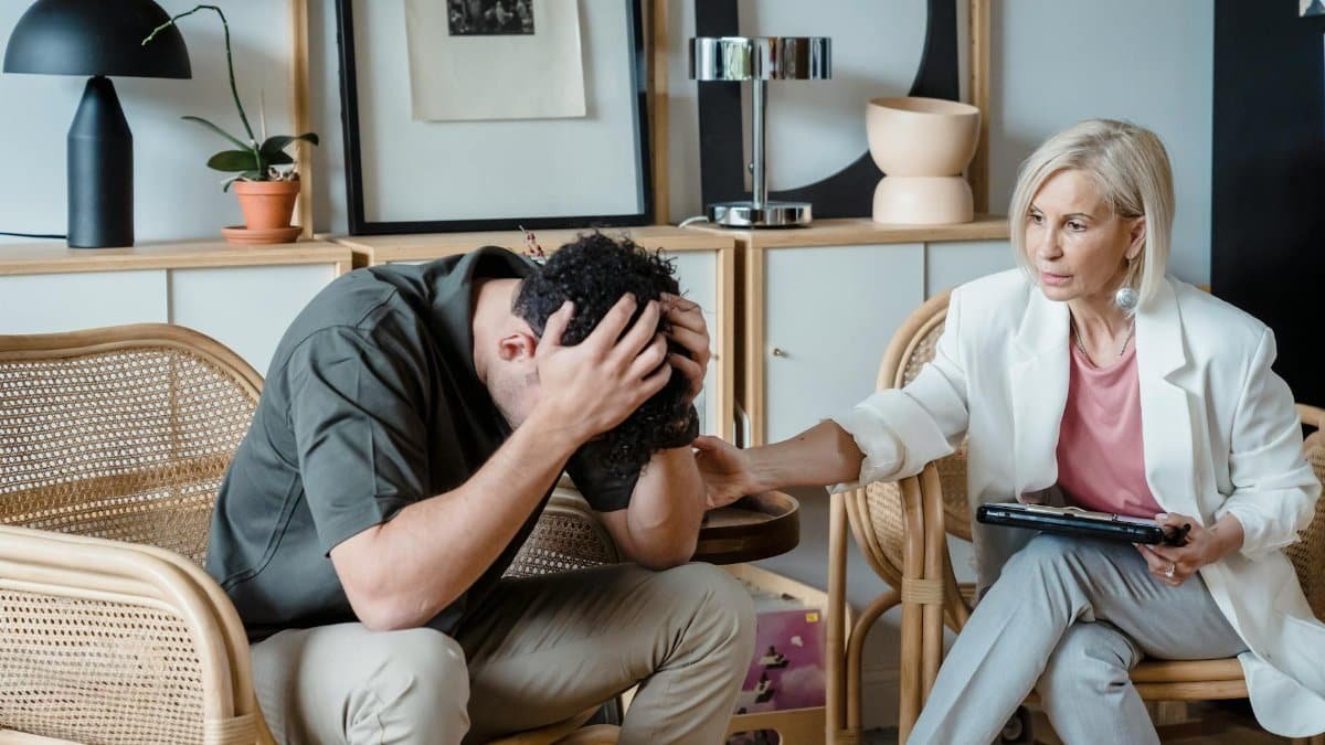 A supportive therapist provides comfort during a counseling session in a cozy office.