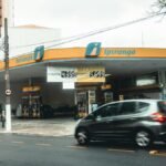 Ipiranga gas station with moving vehicles on a bustling city street.
