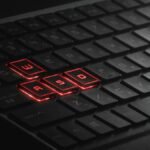 Close-up of illuminated WASD keys on a gaming keyboard with red LED lights.