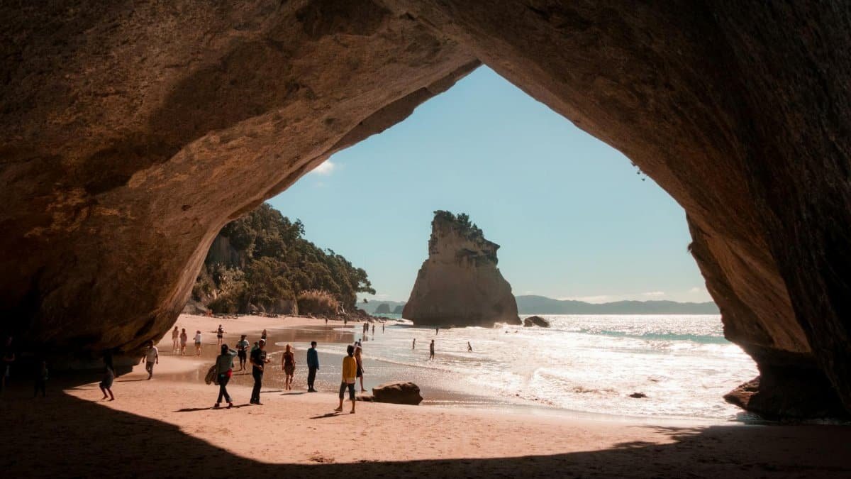 Explore the scenic Cathedral Cove in Hahei, New Zealand with a breathtaking beach view framed by natural rock formations.