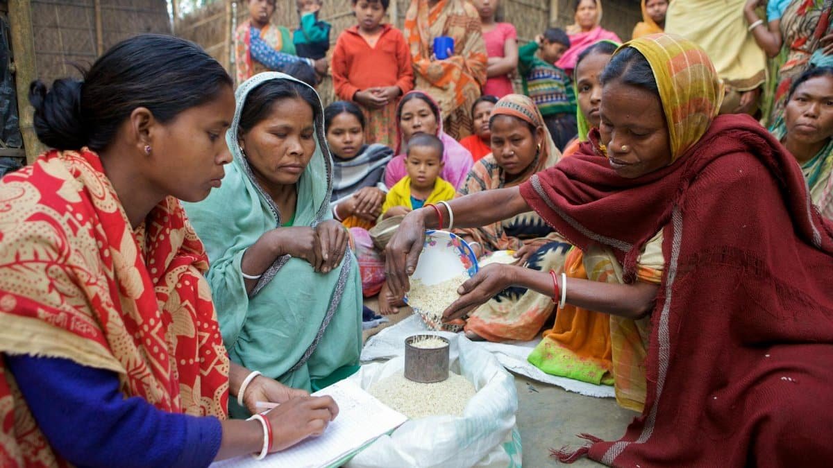 Village women in Bangladesh gather for community development planning and resource distribution.
