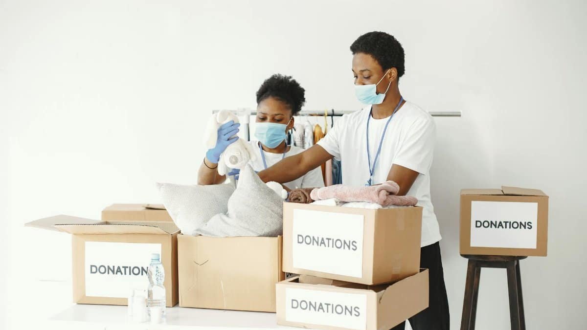 Group of volunteers packing donations for a charitable organization indoors.