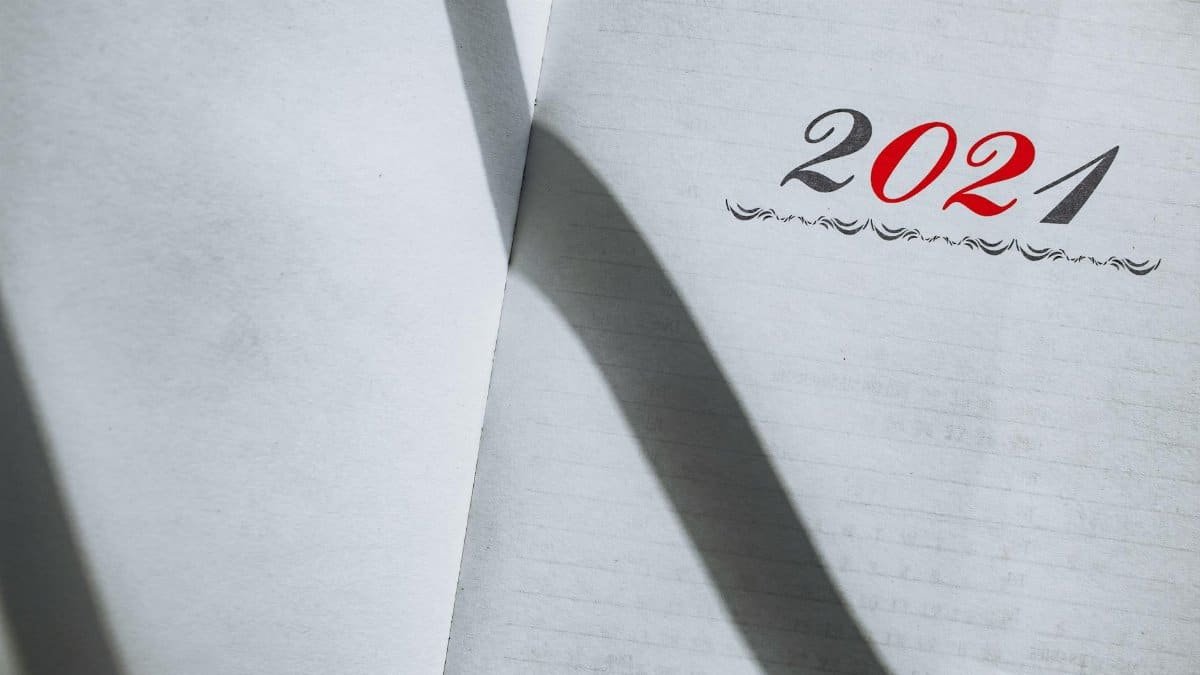 Close-up of an open planner showing the year 2021 with minimalist styling and shadows.