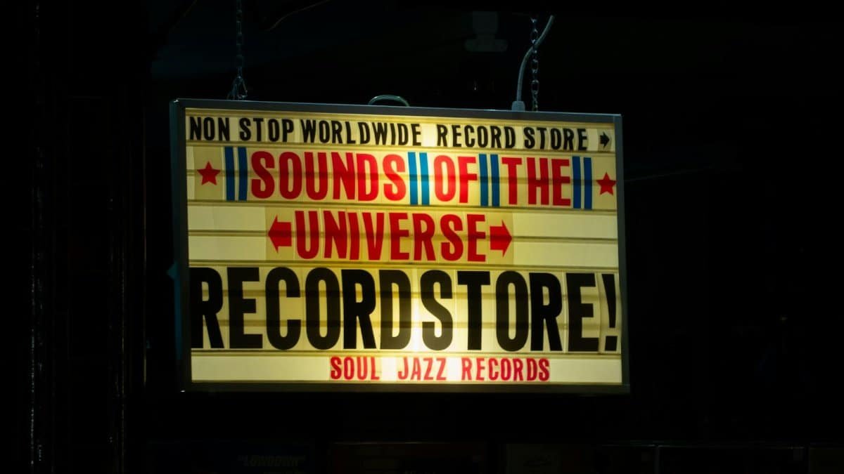 Vibrant record store sign in London's nightscape, promoting Sounds of the Universe.