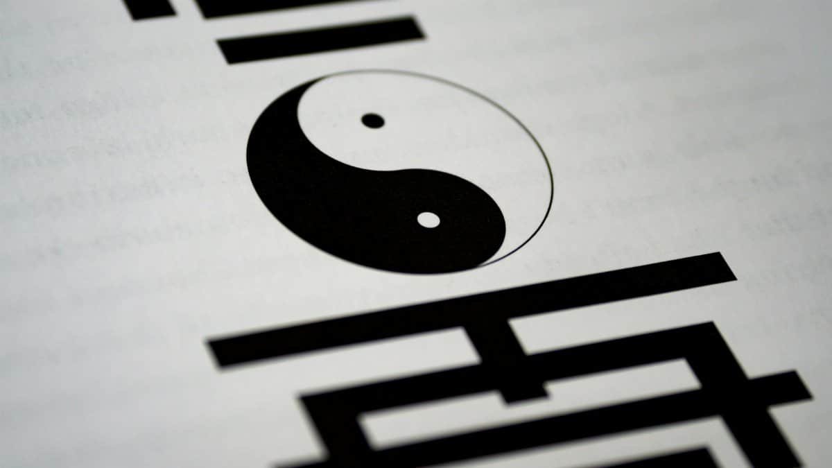 Artistic close-up of yin-yang symbol with Chinese calligraphy on paper.