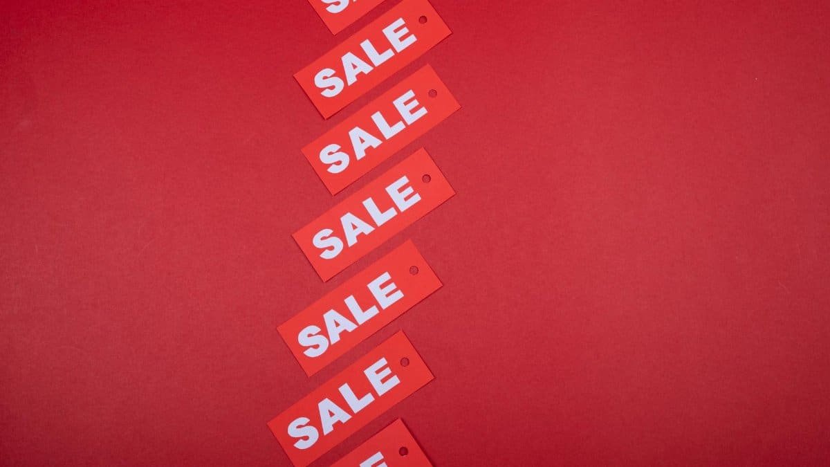 Red sale tags aligned diagonally on a red background, perfect for retail promotions.