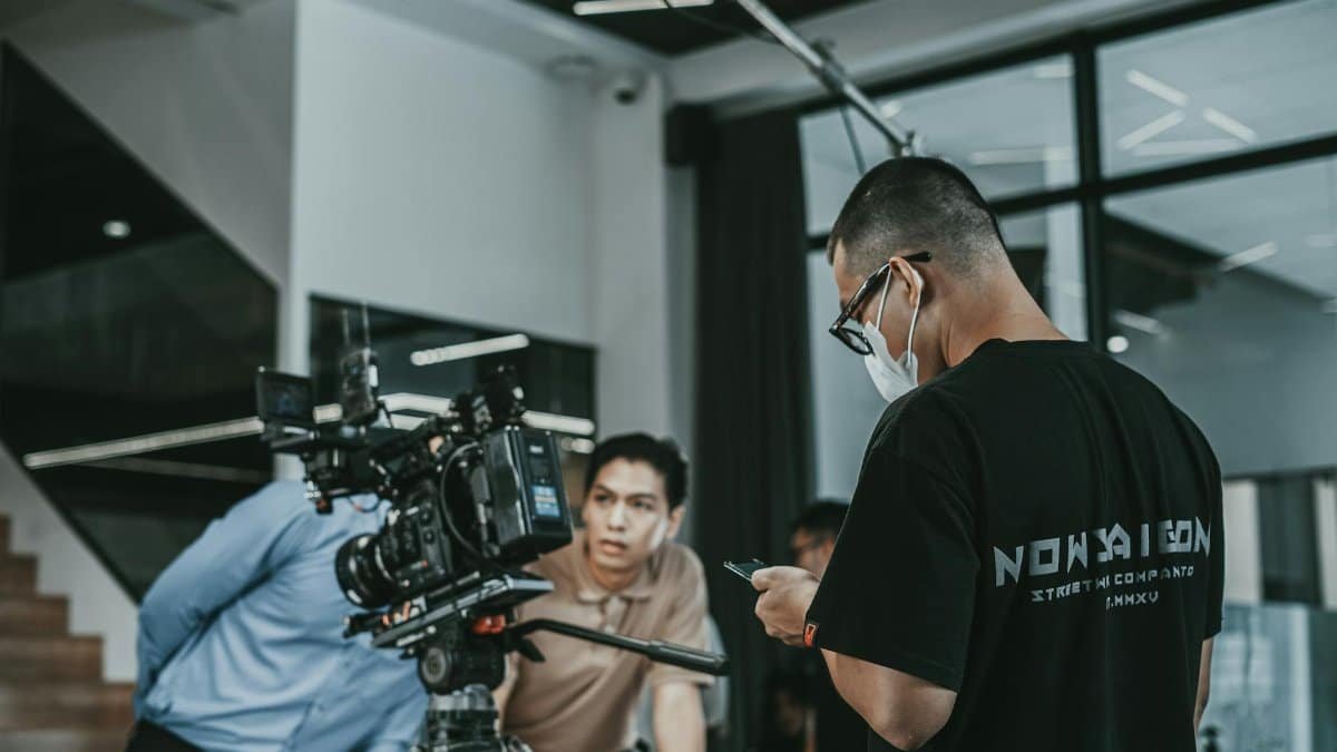Camera crew working on a film set in Vietnam, capturing cinematic scenes indoors.