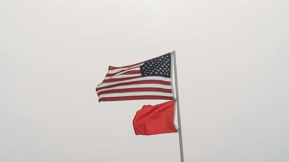 United States and warning flags on display against an overcast sky at Orange Beach, AL.