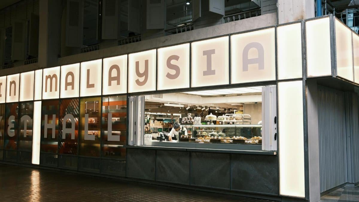 Chef preparing food in a modern urban food hall in Malaysia.