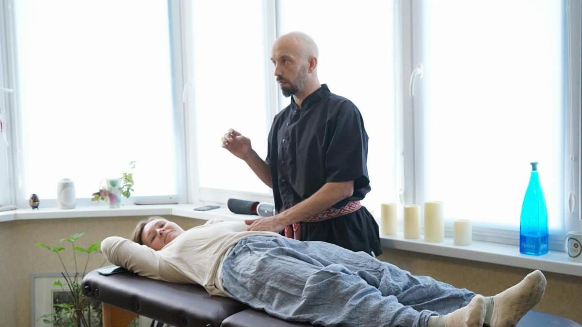 A masseur performing a therapeutic massage on a woman in a relaxing spa setting, promoting wellness.