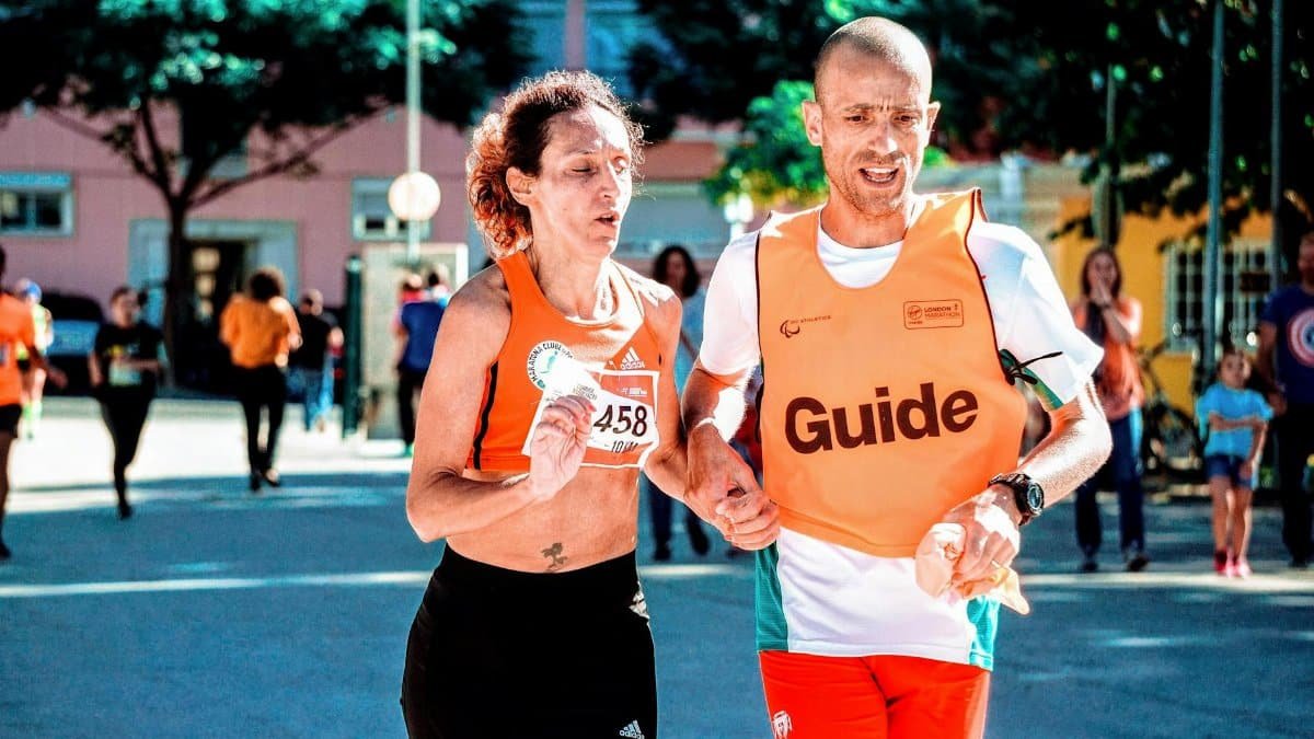 Two runners, a man and a woman, in a marathon with a guide through city streets.