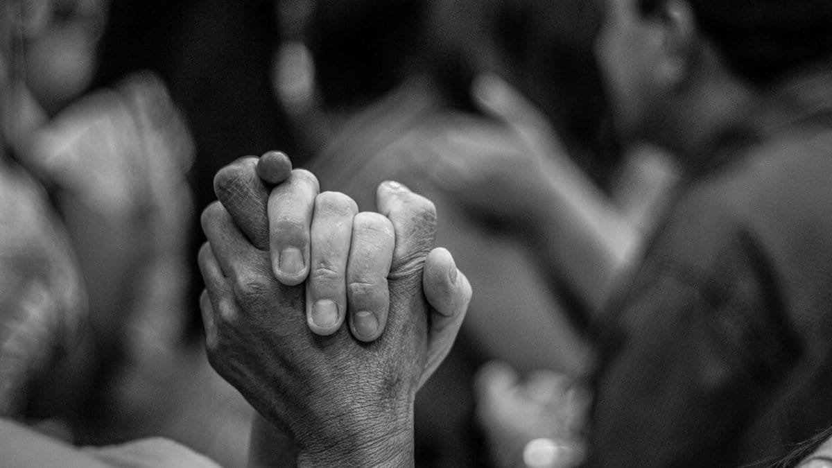 Artistic black and white photo of joined hands symbolizing unity and peace.