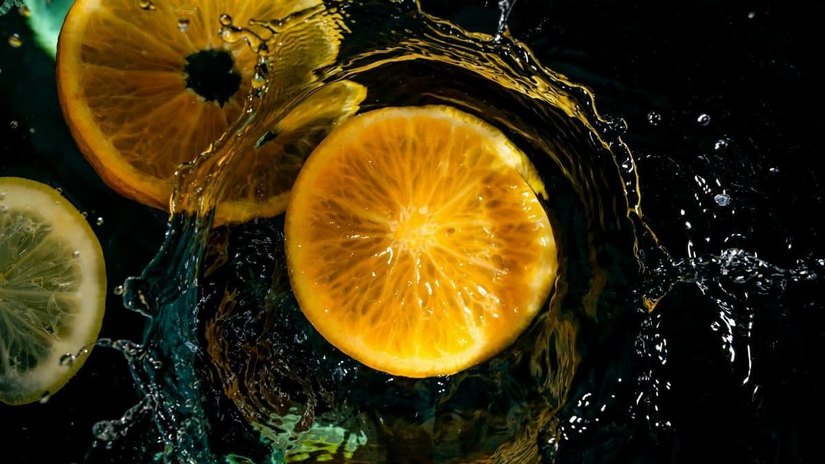 Dynamic citrus fruits create a vibrant splash in water, capturing freshness and energy.