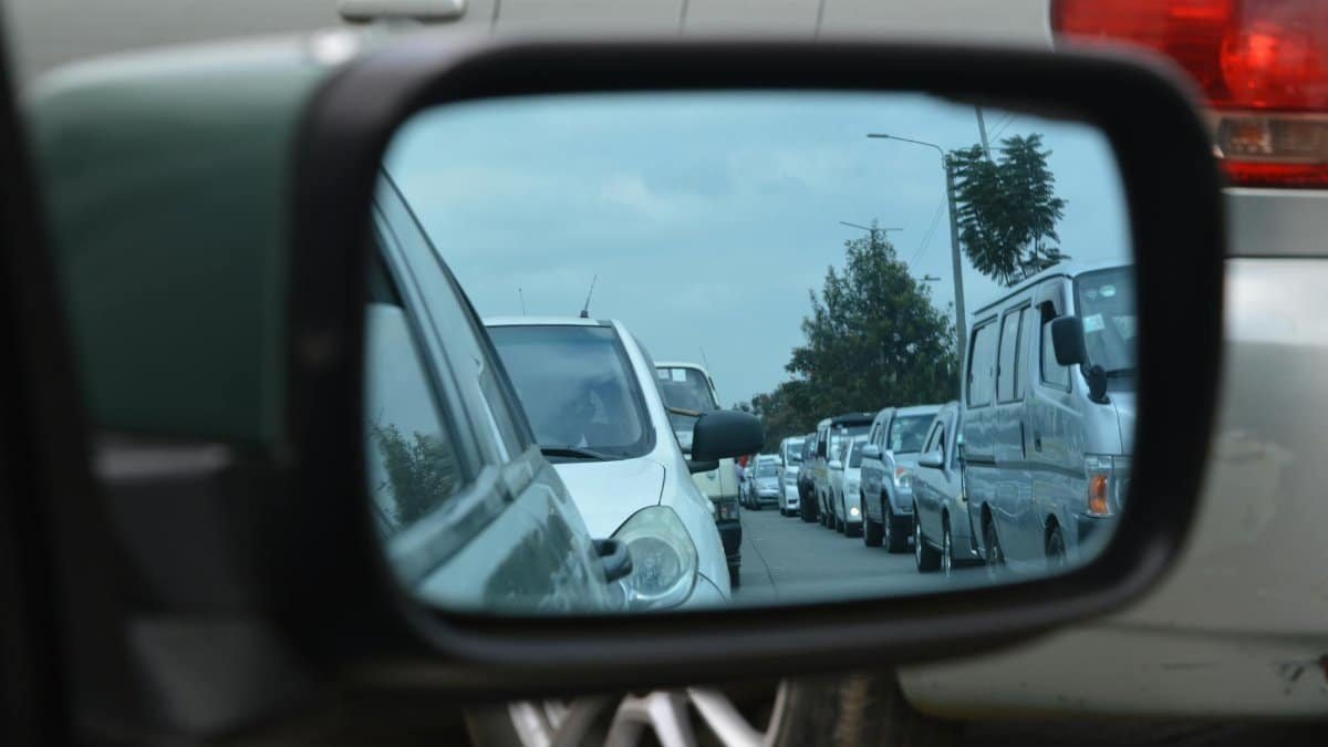 Reflection of a busy traffic jam in Nairobi captured through a car's side mirror.