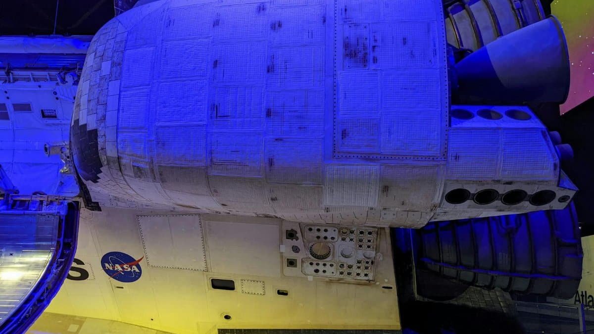 Detailed view of Space Shuttle Atlantis, showcasing engines and NASA logo at a museum exhibit.