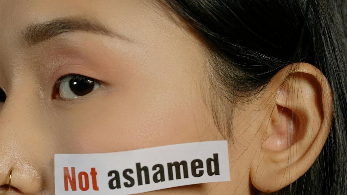 Close-up of a woman with 'Not Ashamed' text symbolizing empowerment and self-acceptance.
